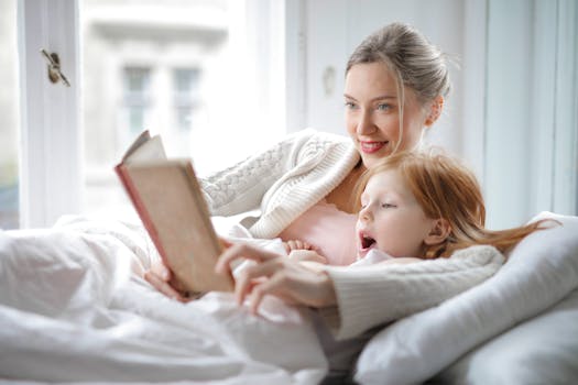 pexels-photo-3755514-3755514 Cheerful young woman hugging cute little girl and reading book together while lying in soft bed in light bedroom at home in daytime