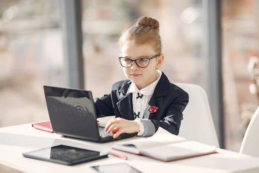pexels-photo-3874369-3874369 A smartly dressed young girl works on a laptop in a modern office setting.